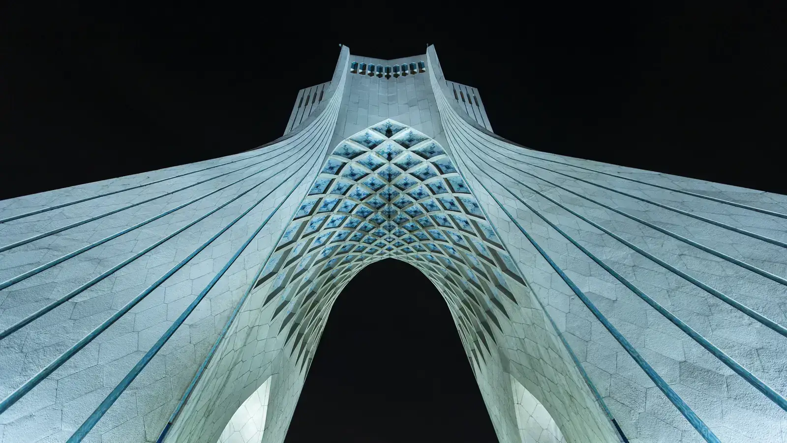 Advisory team reviewing documents over Tehran skyline at dusk